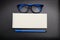 Top view note paper with blue eye glasses and blue pen