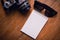 Top view of notebook paper , sunglasses and Ukulele on Office de