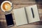 Top view notebook, pen, coffee cup, and phone on wood table, Vintage filter.