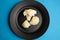 Top view of nutritious white broccoli and boiled potatoes on a black plate