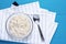 Top view oatmeal in bowl with spoon blue wooden background on kitchen towel