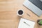 Top view office desk with laptop, notebooks, coffee cup copy space on wooden background.