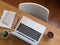 Top view of office desk with laptop, stationery, cactus pot and white chair in office room