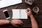 Top view office desk mockup: laptop, notebook, smartphone, pen, flower, and cup of coffee