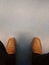 Top view of old black pants and yellow brown leather shoes of relax sitting businessman on floor. Photo is focused at shoes.