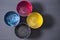 Top view of old CMYK paint cans on dark background. Colorful background.