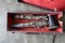 Top view of an old, decayed and damaged black wooden clarinet housed in a collectible storage box.