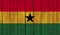 Top view of Old Painted Flag of Ghana on Dark Wooden Fence, wall. patriot and travel concept. no flagpole. Flag background. Plane