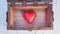 Top view of an old wood with rusty metal Chest opened with a very big and chubby red heart inside