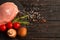 Top view of one pieces raw pork chop steaks with cherry tomatoes Champignon mushrooms on a black stone cutting board