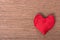 Top view of one red homemade sewn heart on wooden background, co