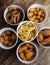 Top view of onion rings, cheese balls, chicken nuggets, wings in batter, fries and cheese sticks. Six-course set in paper buckets