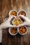 Top view of onion rings, cheese balls, chicken nuggets, wings in batter, fries and cheese sticks. Six-course set in paper buckets