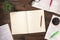 Top view of an open books with cup of coffe, glasses, home plant and open blank notepad on a wooden background