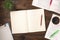 Top view of an open books with cup of coffe, home plant and open blank notepad on a wooden background