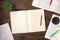 Top view of an open books with cup of coffe, home plant and open blank notepad on a wooden background