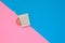 Top view of opened condom and red condom in pack on blue and pink color paper background with copy space for text.