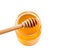 Top of view of opened honey jar on white background with wooden honey dipper on top