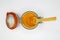 Top view on opening of isolated preserving glass jar with red rubber ring and yellow turmeric curcuma powder, wood spoon, white