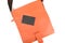 Top view,Orange leather bag with black price tag on white background