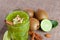 A top view of an organic smoothie with kiwi and almond on a light cloth background. Kiwi fruit and cinnamon on a desk.