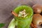 A top view of an organic smoothie with kiwi and almond on a light cloth background. Kiwi fruit and cinnamon on a desk.