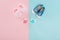 Top view of pacifiers, booties, sneakers on pink and blue background with copy space.