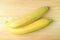 Top View of a Pair of Bright Yellow Ripe Bananas on Wooden Table