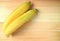 Top View of a Pair of Bright Yellow Ripe Bananas on Wooden Table, with Free Space