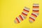 Top view of a pair of colored socks on a yellow background. Clothing in the form of socks