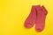 Top view of a pair of colored socks on a yellow background. Clothing in the form of socks