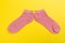 Top view of a pair of colored socks on a yellow background. Clothing in the form of socks