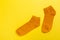 Top view of a pair of colored socks on a yellow background. Clothing in the form of socks