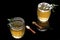 Top view of a pair of glass of Kahwa,Indian Kashmiri herbal summer tea topped with ice cubes and saffron on black background