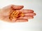 Top view of a palm hand on white background holding handful of omega pills capsules as healthy cure, supplement and prevention