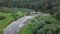 Top view of panorama of river passing through forest. Stock footage. Beautiful view of river reflecting sky and