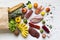 Top view, paper bag of different healthy products over white wooden background.