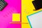 Top view paper lying pencil highlighter sticky note clips calculator wallet colored magenta and yellow background