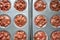 Top view of paper muffin molds with corrugated sides, filled with chocolate dough with cherries in baking dish