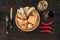 top view of parmesan cheese with baguette slices on wooden board, chili peppers and wine