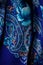 Top view part of blue paisley floral pattern on dark cotton female shawl
