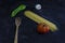 Top view of pasta background with spaghetti ,green pepper,tomato,garlic and a wood spoon on floury dark background