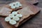 Top view of Peanut butter banana toasts on wooden background. Slices of whole wheat bran bread with peanut paste on cutting board