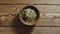 TOP VIEW: Peeled pumpkin seeds fill wooden cup on a wooden table