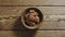 TOP VIEW: Peeled walnuts fill wooden cup on a wooden table