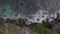 Top view on a Peguyangan waterfall against a background of crashing waves on a rocky shore.