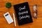 Top view of pen,calculator,eyeglasses,plant and notebook written with Small Business Saturday on wooden background.