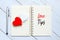 Top view of pen,red heart on a notebook written with LOVE TIPS.