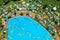 Top view of people relaxing in the pool on yellow inflatable circles and sun beds on the beach