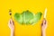 Top view of person holding fork and knife while eating healthy cabbage